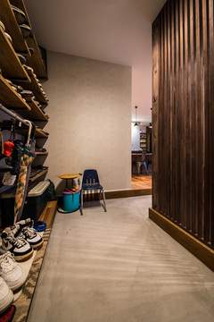 玄関には土間収納をたっぷり設けてある。オープンラックに靴を並べて、ハンガーパイプに服をかけ、見た目にもオシャレな収納が実現