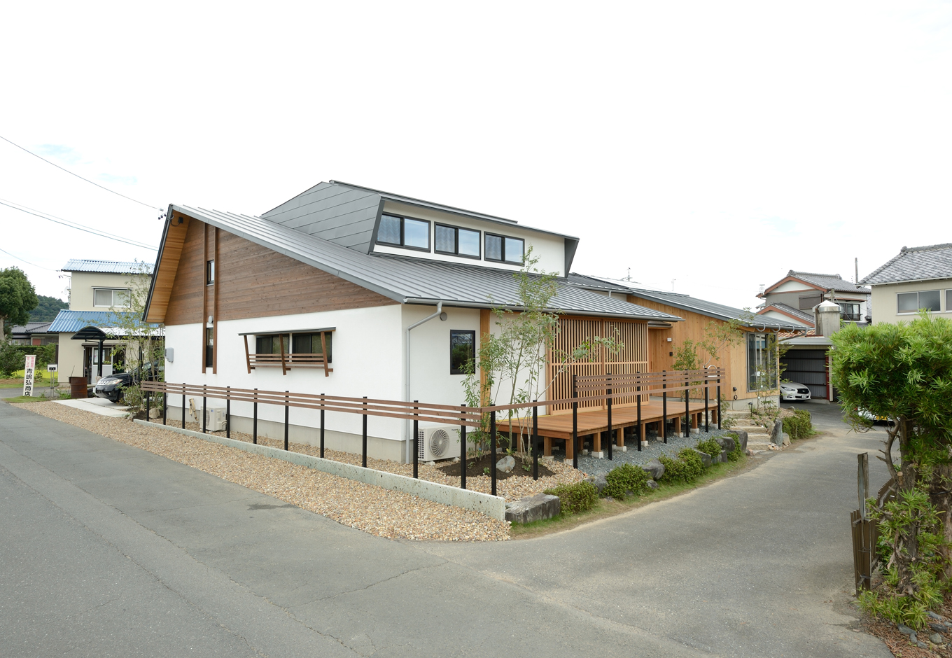 石牧建築【デザイン住宅、二世帯住宅、建築家】屋根の形が複雑で別々になっていそうだが、実は１枚につながっている「ひとつ屋根の家」。この形状の屋根の施工は非常に難しく、高度な技術を備えた同社だからこそ実現できたもの。玄関は親世帯が南側、子世帯が北側。どちらの世帯にも適所に緑を配し、南東からの光をたっぷり採り込めるように配慮されている