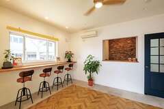 1階店舗の商談ルーム。受付背面はウッドチップのアクセントウォールでニュアンスを出した