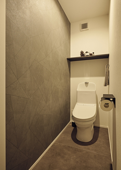 床のタイルと壁をグレーでまとめたトイレ