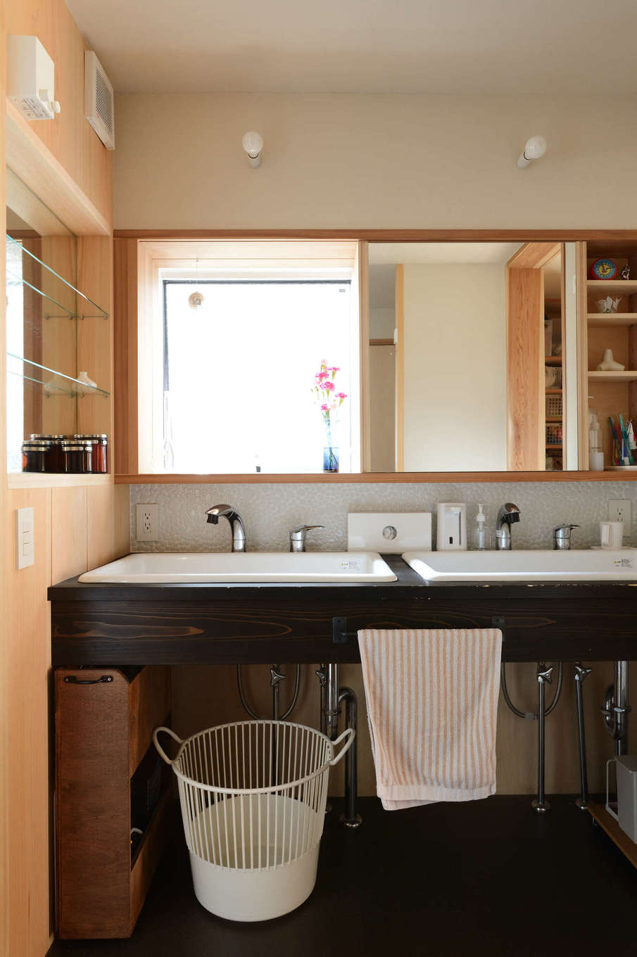 石牧建築【自然素材、狭小住宅、建築家】キッチンと浴室の中間に位置する洗面脱衣室。洗面台は漆塗り仕上げ。女性が多い家族なので、朝の混雑解消を目的に深底シンクを2つ設けた（実際は、ご主人がいちばん長い時間使用している）。鏡の下のタイルは、石牧社長と多治見のタイルミュージアムまで足を運んでセレクトしたもの