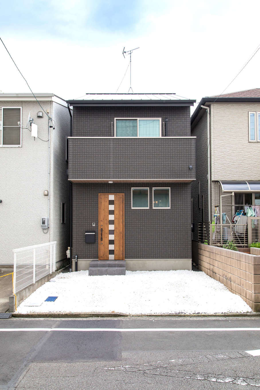 建築システム（狭小住宅専門店）【1000万円台、狭小住宅、インテリア】外観は黒を基調に玄関ドアや軒天井に木調を用いてナチュラルさをプラス。隣家との隙間はわずか40cmほど。これが『建築システム』が誇る隙間職人の実力