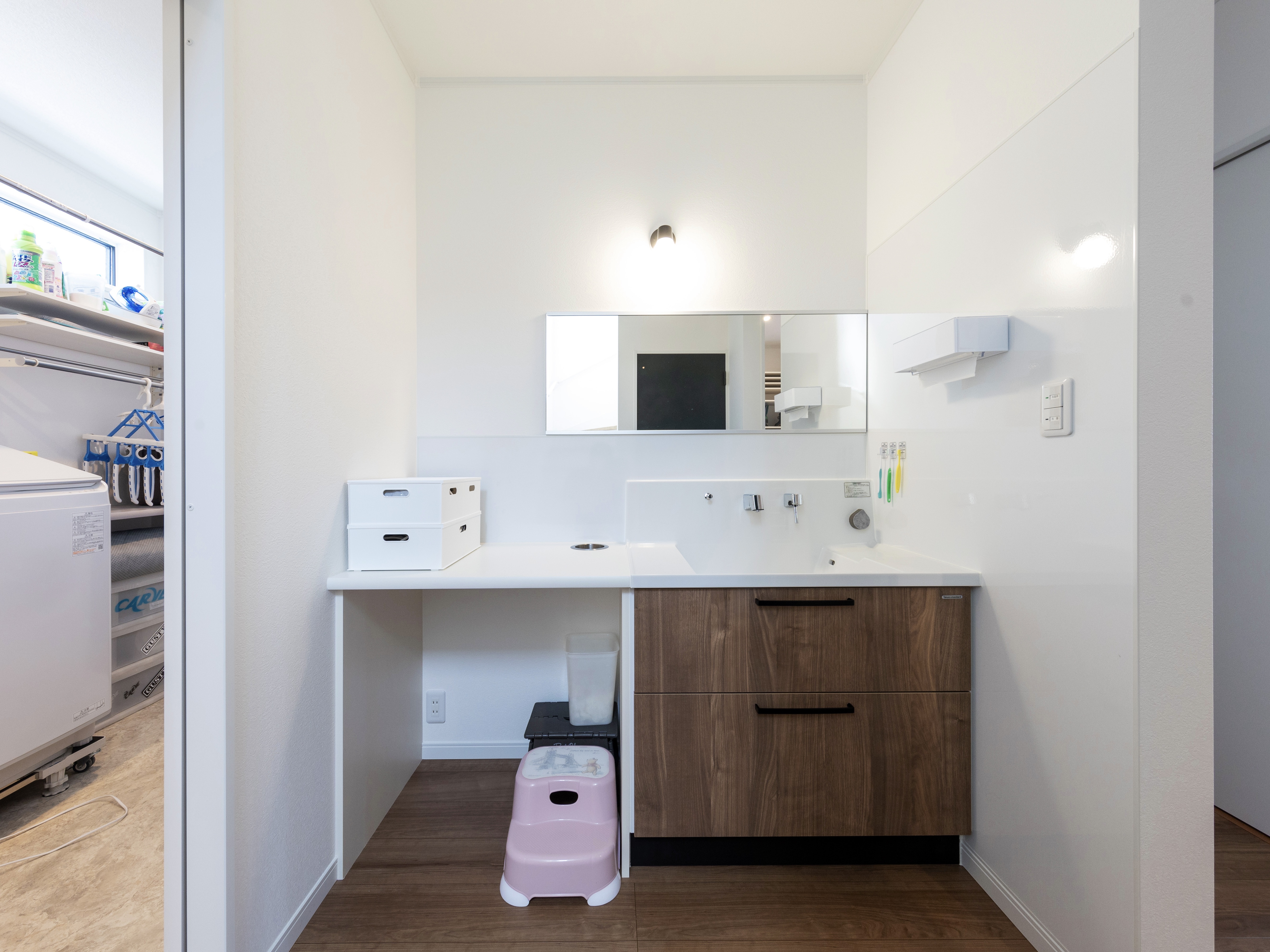 エスホーム｜玄関に近い場所に設置したことで、帰宅後すぐに手洗いができる。ナチュラルな木目調のキャビネットと白を基調としたシンプルなデザインで、毎日の身支度が快適になる空間。