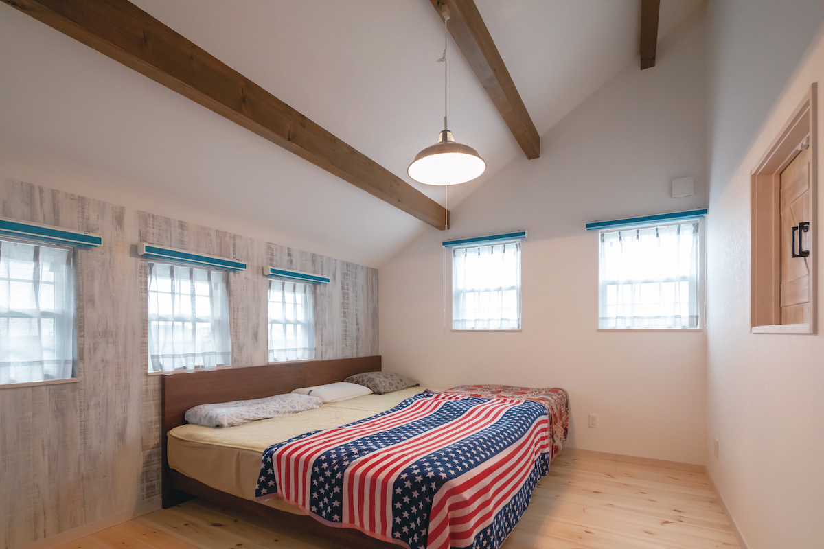 富士ホームズデザイン【子育て、自然素材、インテリア】窓の多い主寝室は明るい雰囲気。勾配天井で空間の広がりも演出した