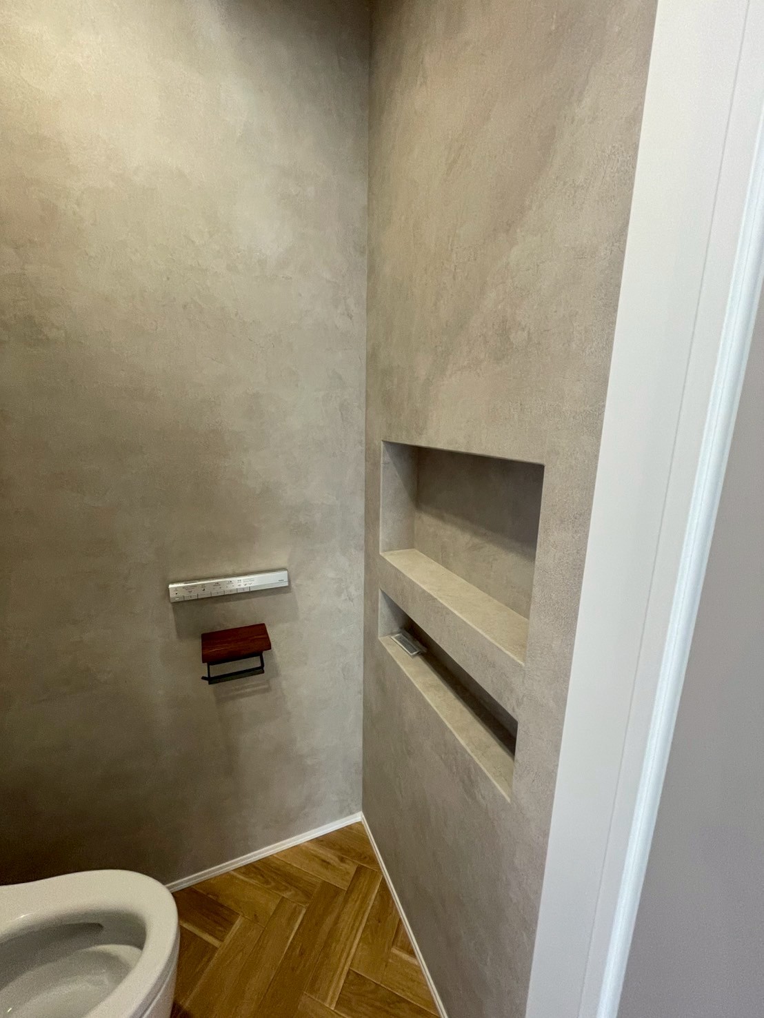 英知工務店｜シンプルでモダンなデザインのトイレ。壁面のニッチはトイレットペーパーのサイズに合わせてお造りしました。収納として活用可能で、清潔感溢れる空間に仕上がっています。