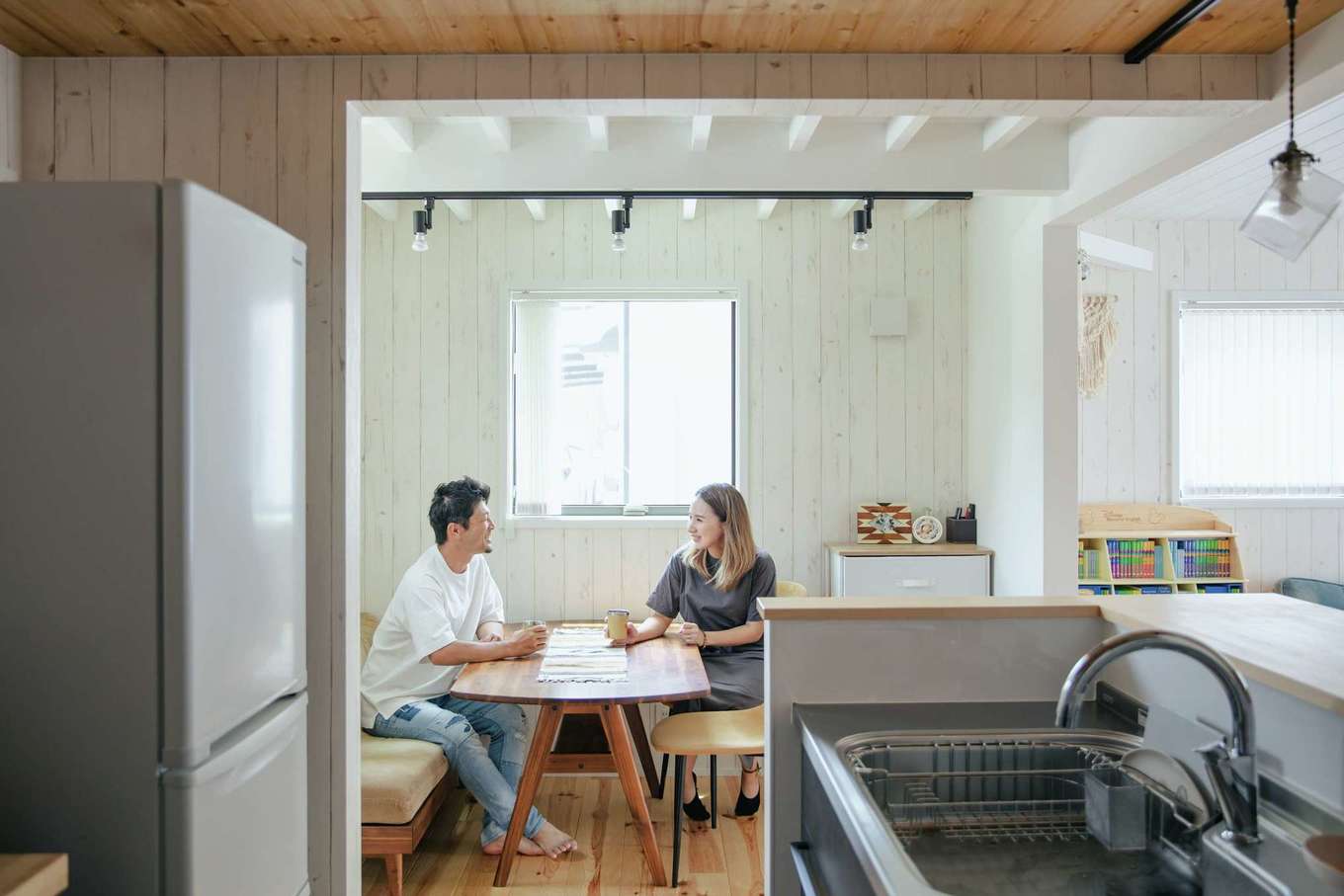 ハートホーム【デザイン住宅、趣味、スキップフロア】「全部白く塗ってしまうと落ち着きがなくなって、ハリの量が多いと印象が重くなりそう」と、天井の高さ、ハリの見せ方、白くペイントするかを吟味した。構造上必要だった壁がダイニングの適度な目隠しに