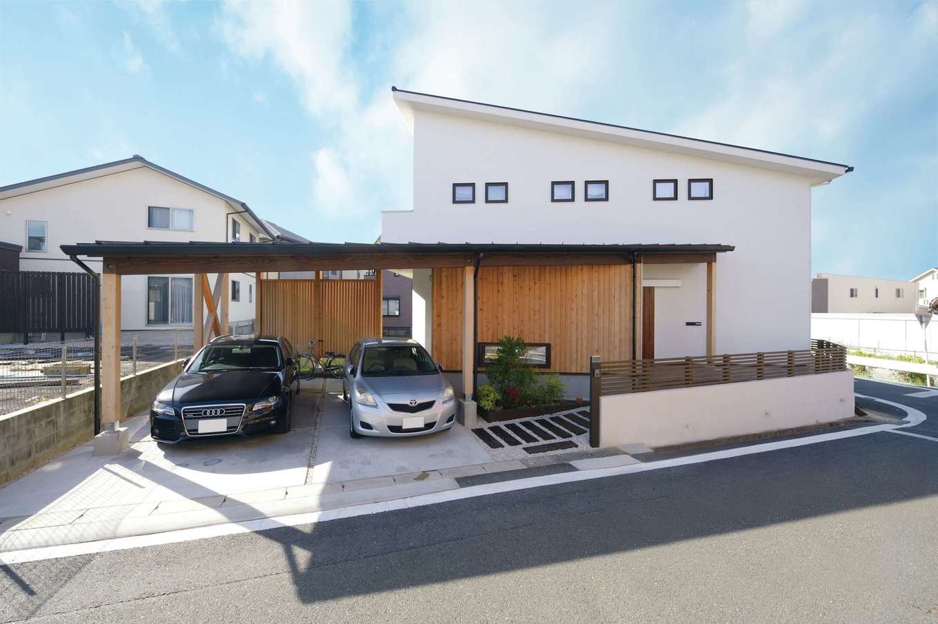 アイジースタイルハウス【デザイン住宅、自然素材、間取り】街の景観に溶け込んだシンプルモダンな外観。建物と一体型のカーポートが家をより大きく見せる。小窓の配置、木の壁がアクセントになっており、エクステリアにもとことんこだわった