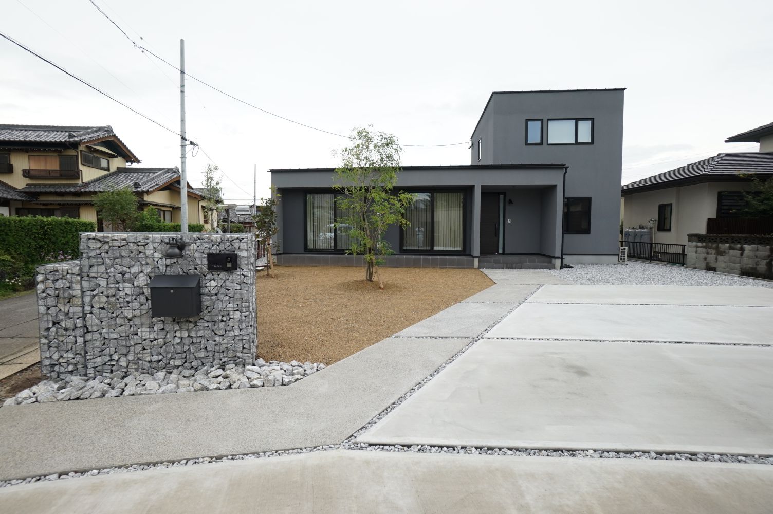 RIKYU 一級建築士事務所【間取り、建築家、インテリア】100坪を超える広大な土地に建てた30坪の家。リゾートのような開放感が漂い、ガビオンの門柱がゲストをお出迎え。庭のスモークツリーもいい感じ。外からの視線を遮るために、西側に窓を設けない代わりに、各個室とも2面採光を確保した。2階は子ども部屋だけなので、将来的にも無駄がない