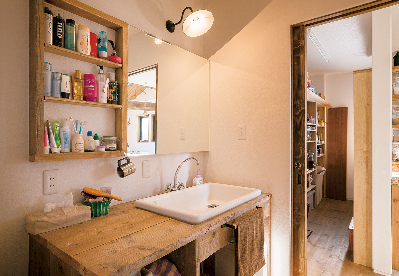 富士ホームズデザイン【デザイン住宅、子育て、インテリア】建築の足場板を使用したオリジナルの洗面台。奥に見えるのはキッチンの裏手にあたるパント リー。「他の家で見て絶対に取り入れたかった」と奥さま