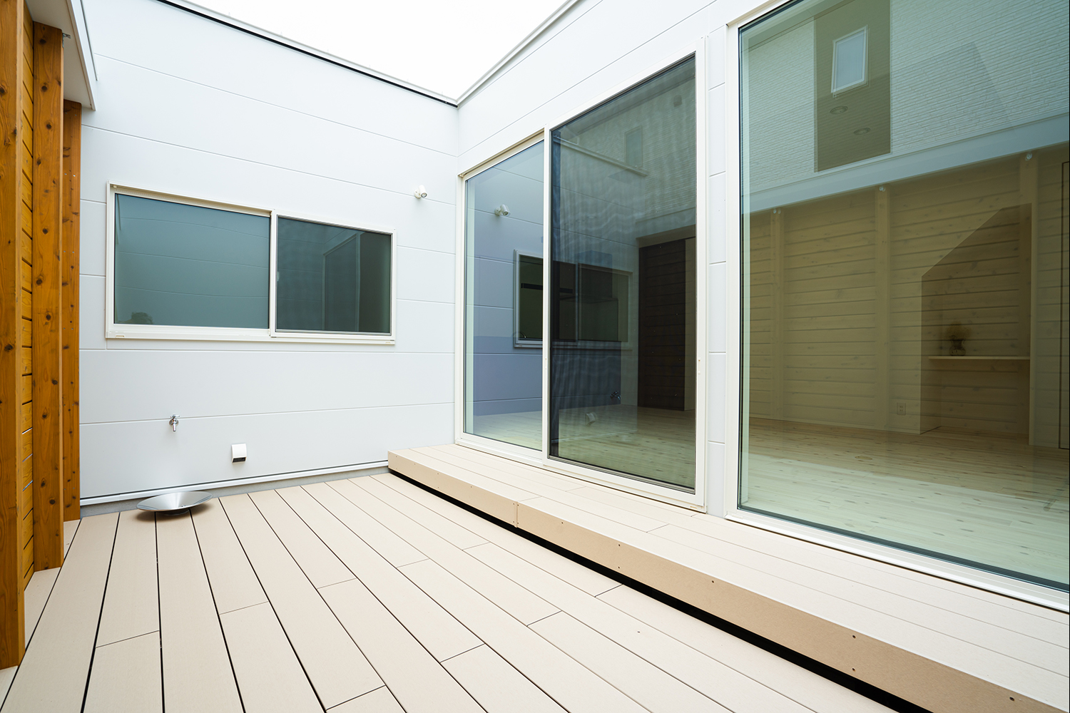 ETERNITY（エタニティ)　SIMPLE NOTE 浜松東【デザイン住宅、建築家、ガレージ】リビングの外にある、家族だけのプライベートな中庭は特別な場所だ。段差を生かしてベンチがわりに座ったり、シートを敷いてピクニック気分で食事をしたり。水栓が用意され、ここでのプール遊びなども自由自在