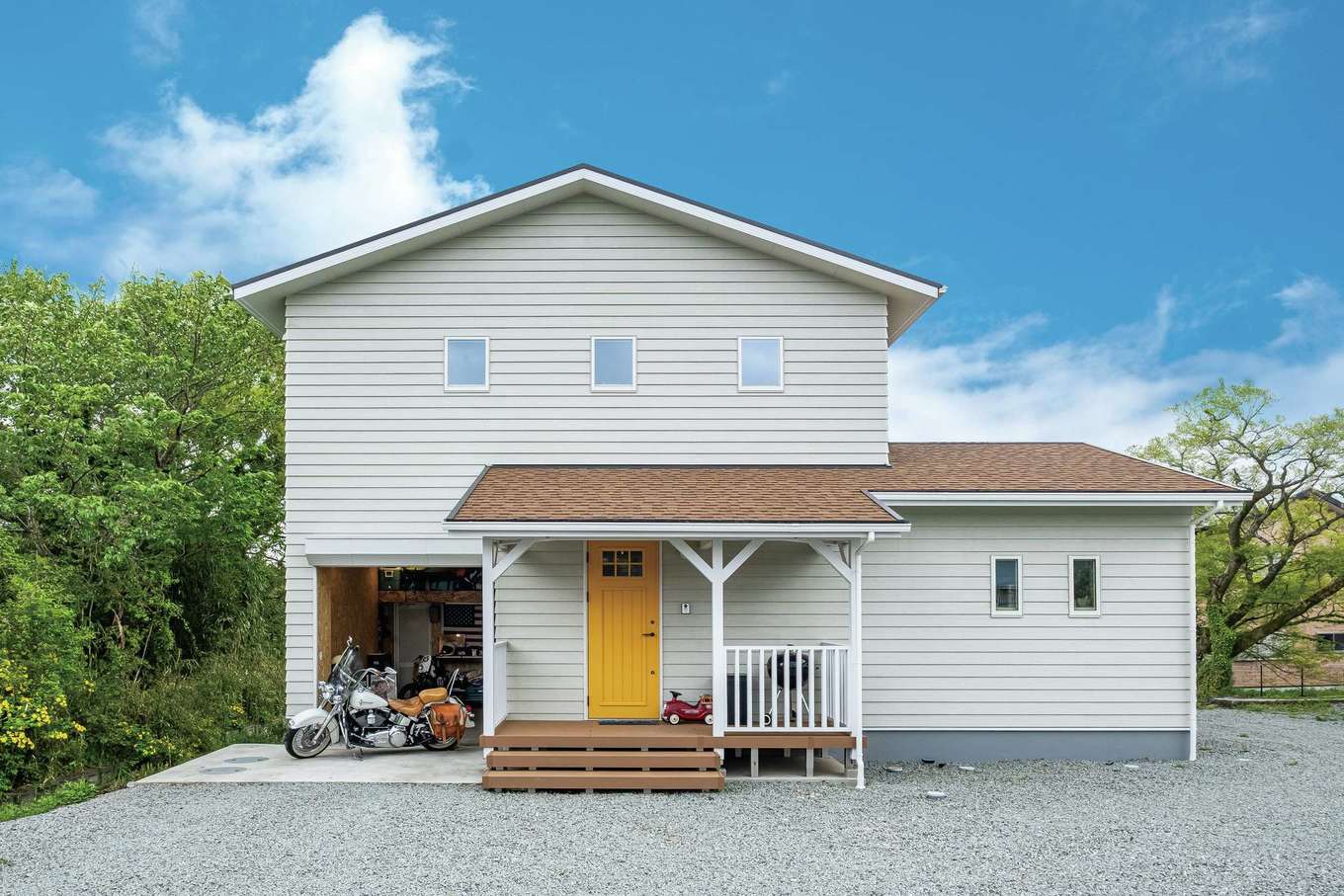 住起産業（アキュラホーム三島中店）｜160坪の広大な土地に完成したI邸。キャメルの三角屋根と白いラップサイディングが融合したアメリカンサーファーズハウスは、「御殿場にハワイができた！」と近隣のランドマーク的な存在になっているそう。シンボリックな黄色い玄関ドアはご主人自ら塗装した