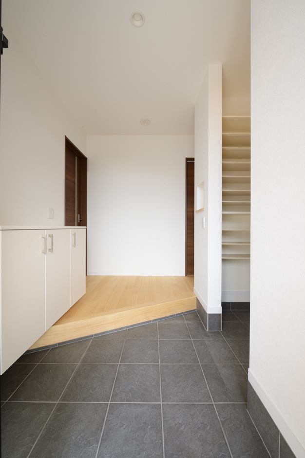 Yamaguchi Design 【収納力、二世帯住宅、間取り】二世帯共有の玄関。大容量の土間収納を設け、散らかりがちな玄関も常にすっきりと見せることができる