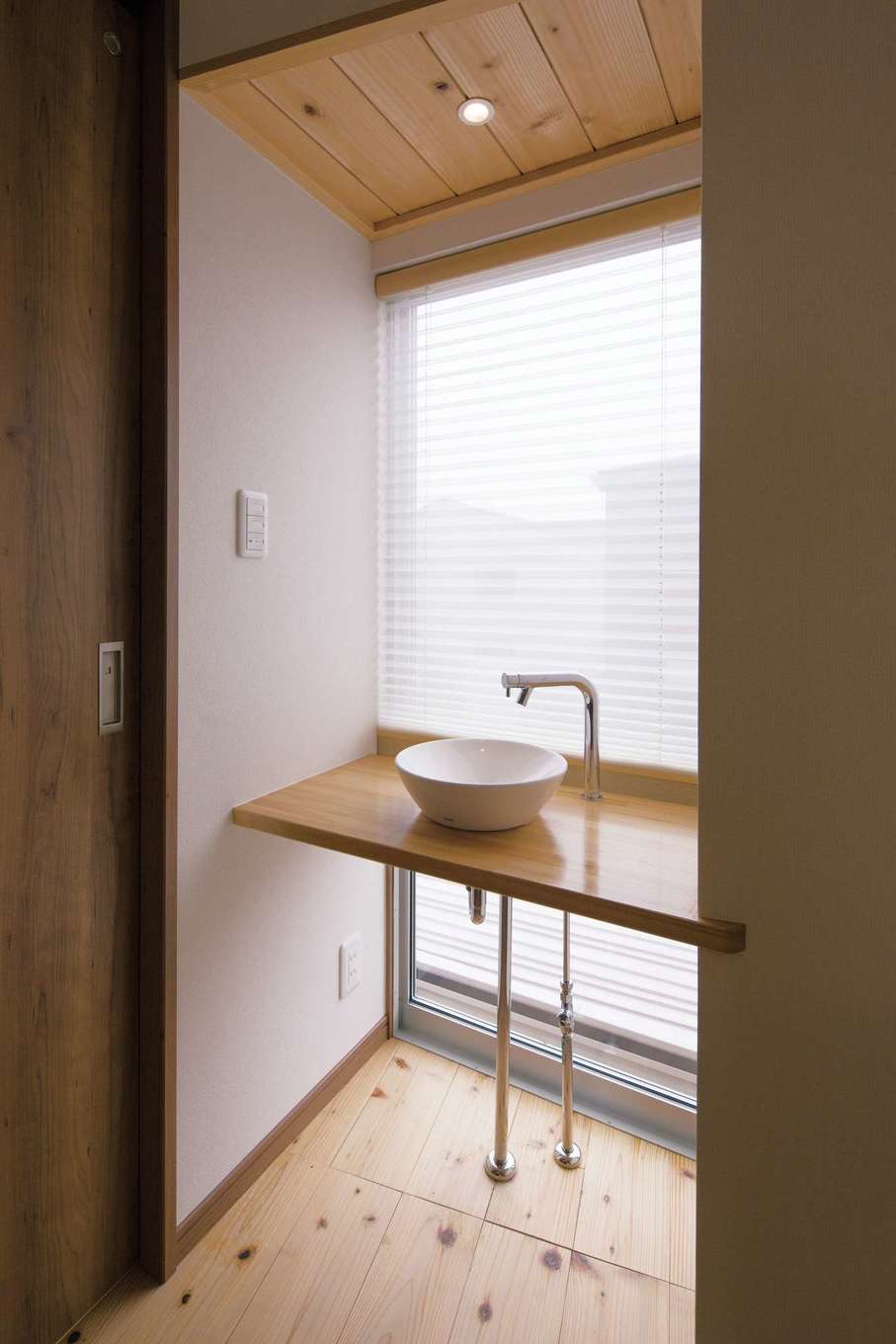 丸洋建設 ハウスオブハウス【自然素材、間取り、デザイン住宅】FIXの大きな窓から眺望を楽しめる2階の洗面台。無垢のカウンター、洗面ボウル、むき出しの水道管がバランス良く調和している