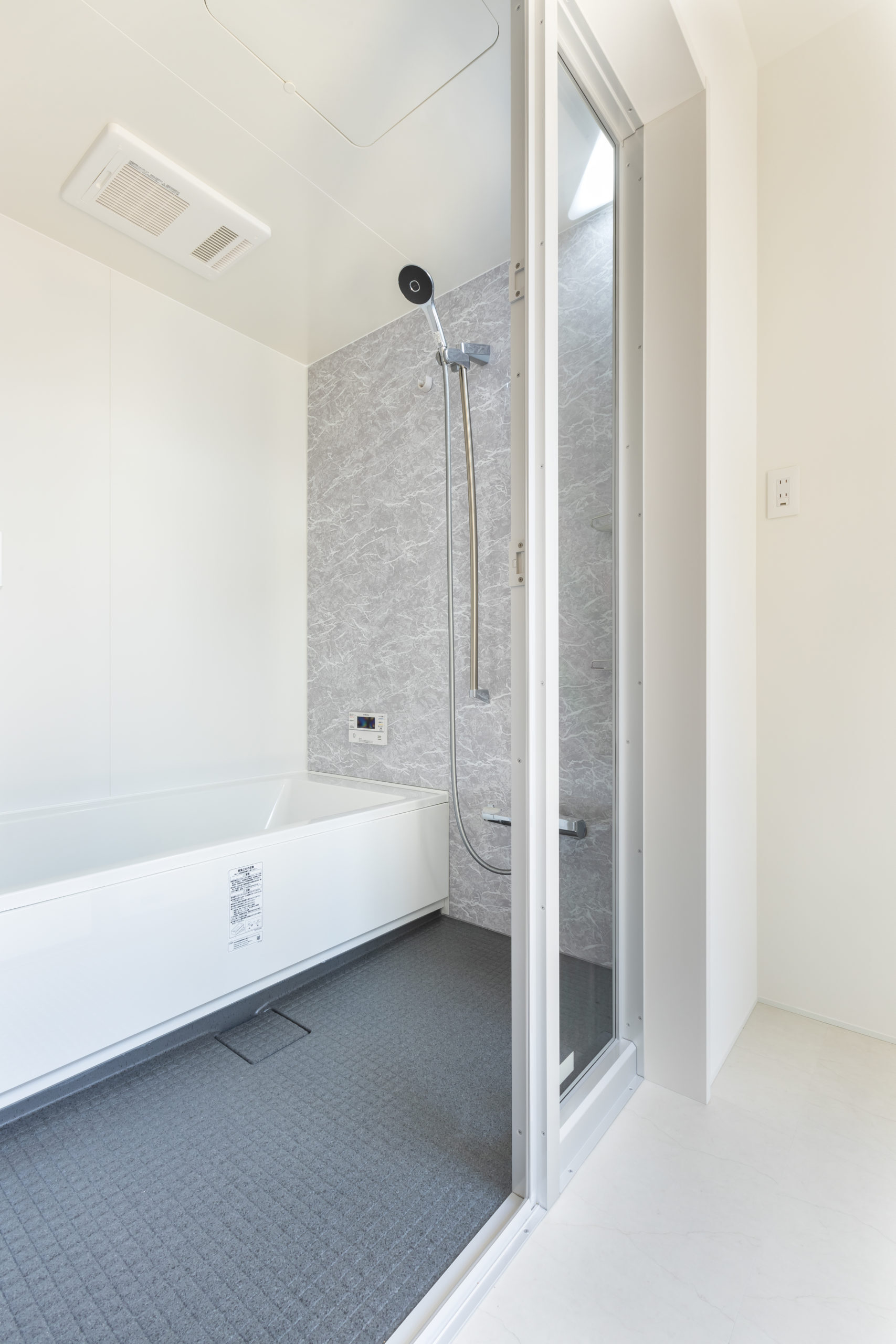 ETERNITY（エタニティ)　SIMPLE NOTE 浜松東【デザイン住宅、建築家、平屋】脱衣所と隣り合う浴室も開放感でいっぱい。夜は窓越しに中庭の空を眺めながら入浴することもできる