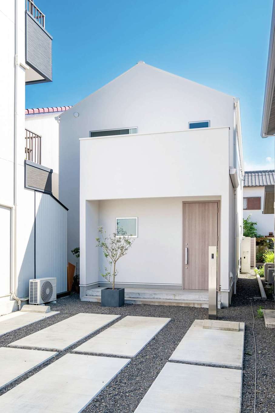 ハートホーム【デザイン住宅、高級住宅、間取り】玄関側の外壁はコテ跡の表情を残した塗り壁。お二人の好みに合わせてグレーがかった白を選んだ