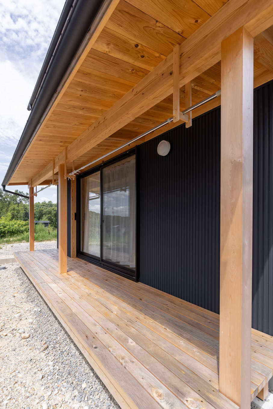 有吉住宅【収納力、自然素材、間取り】リビングの掃き出し窓を開けると縁側が広がる。1階で家事が完結するよう、軒下を洗濯物干しスペースとして活用