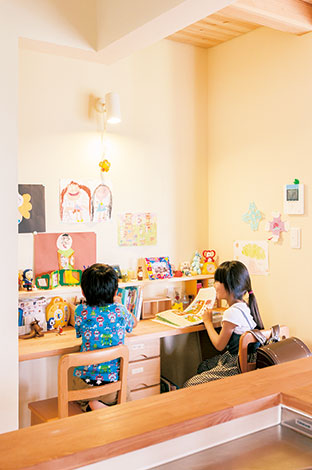福工房【子育て、自然素材、間取り】リビングの一角に設けられたスタディコー ナー。キッチンのすぐ横なので、家事をしながら宿題を見たり、本読みを聞いたり。前の棚や壁は、大切な「作品」の展示スペースに