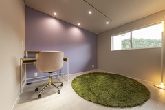 スキップフロア上部の妻のアトリエは、パープルのアクセントクロスで上品な雰囲気。南側の窓から日差しが入るため明るく、目線が抜けるので開放感も得られる