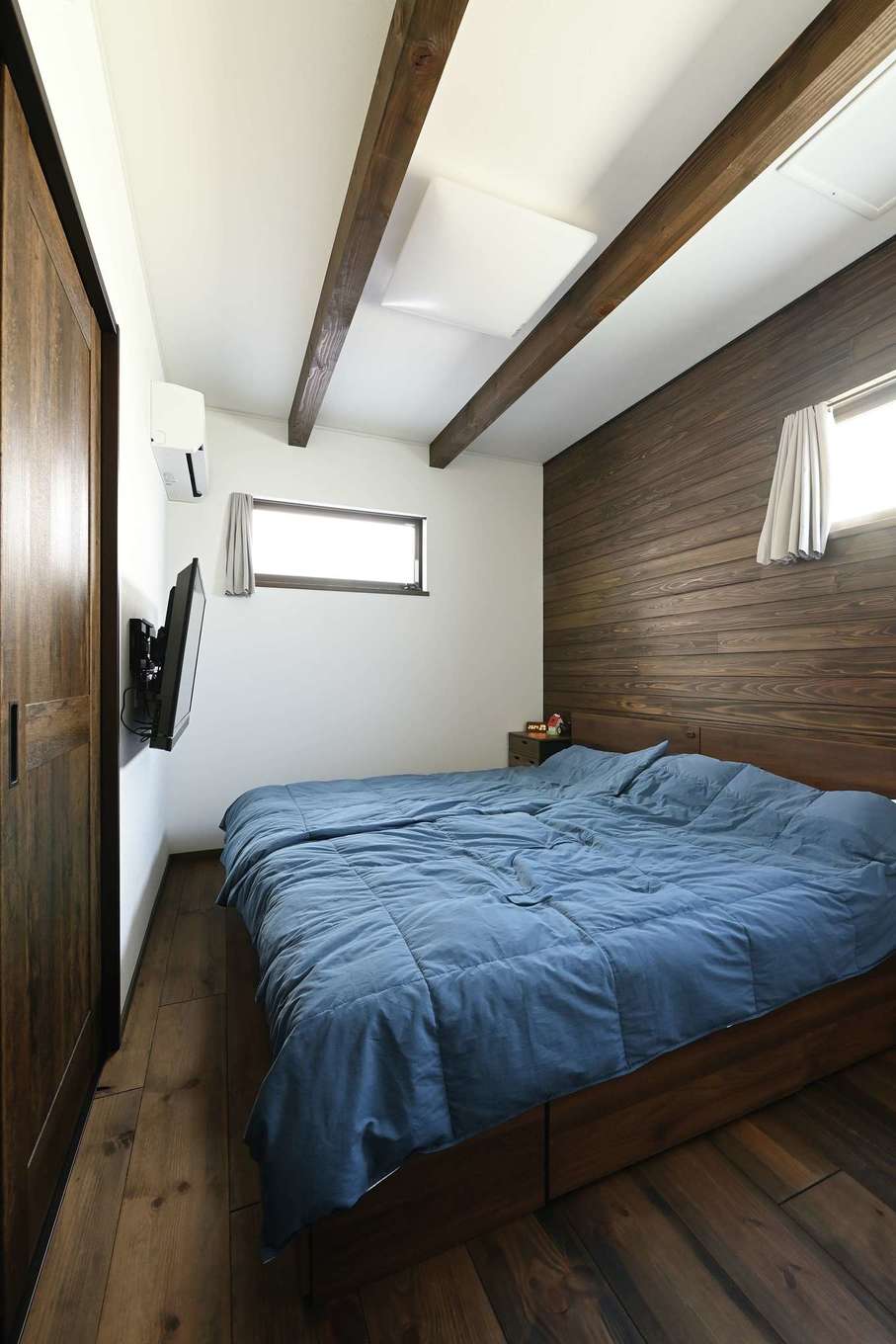 TDホーム静岡西 ウエストンホームズ【1000万円台、デザイン住宅、和風】寝室もほっと落ち着く仕上がり。壁の一面に無垢が張られ、山小屋のようなあたたかみが添えられている。右手にはウォークインクローゼットを用意