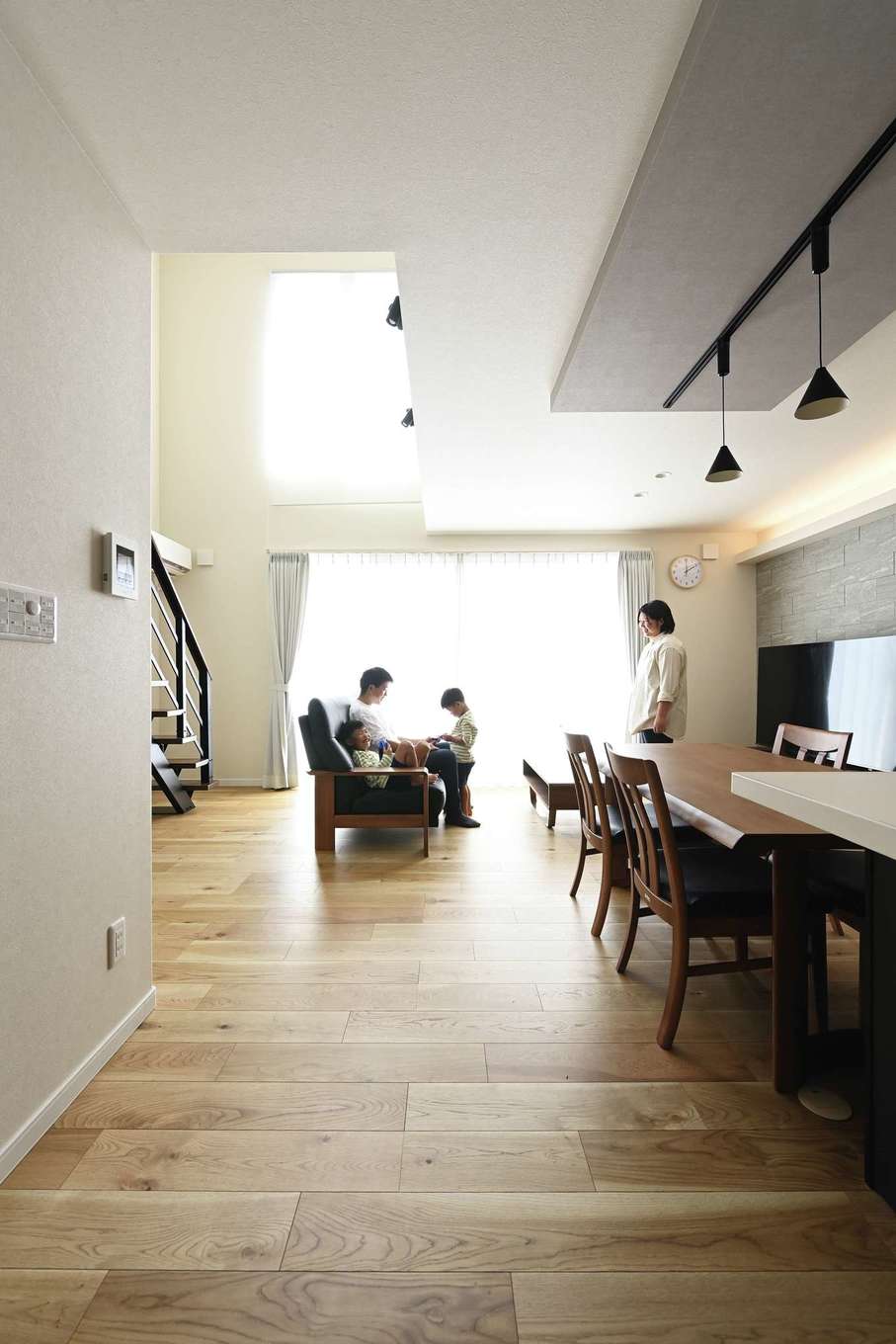 Yamaguchi Design 掛川店（アイフルホーム 掛川店）【デザイン住宅、子育て、間取り】敷地が縦長で住宅が隣接しているため、室内全体に明るさが行き渡るよう、リビングを吹き抜けに。その結果、十分な採光を確保でき、室内全体に開放感が生まれた。2階にいる家族の気配も感じとれるので、コミュニケーションが取りやすい