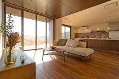 開放的な雰囲気のLDK。大きな窓から自然光が注ぎ込み、明るく心地よい空間を演出。家族団らんに最適である。