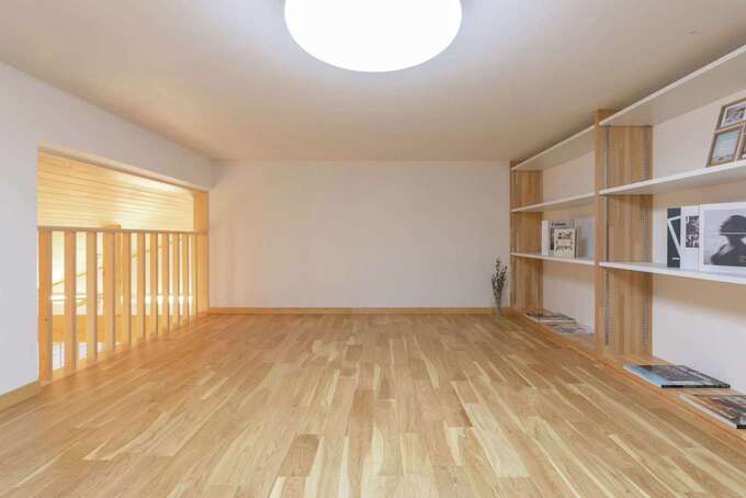 壁に映画などを投影できる照明一体型プロジェクターを備えたロフト。ものに合わせて棚の高さを変更できる大容量の壁面収納もポイントだ