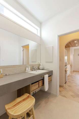 造作カウンターを取り入れた洗面コーナー。横幅約1.8mのカウンターは大人ふたりが並んで支えるサイズ感。スツールに座ってメイクがしやすい高さにデザイン