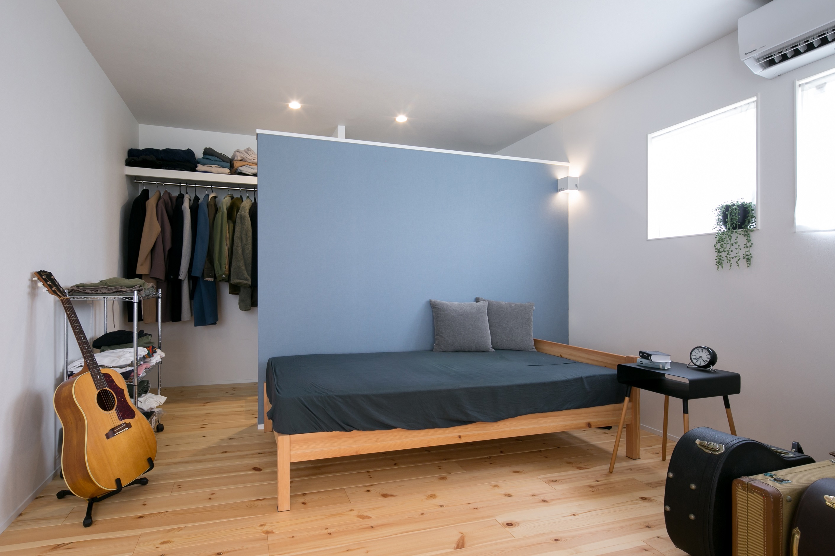 シンプル｜ブルーのアクセントクロスが映える寝室。WICと天井をつなげることで視覚的に部屋を広くし圧迫感をなくした。