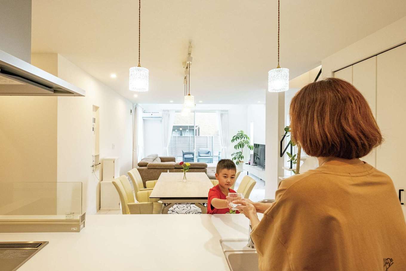 三和建設【子育て、収納力、間取り】キッチンからダイニング、リビング、ウッドデッキまで、一直線につながる間取りはとてもシンプル。オープンスタイルの対面キッチンからは子どもがいつも視界に入り、コミュニケーションもとりやすい