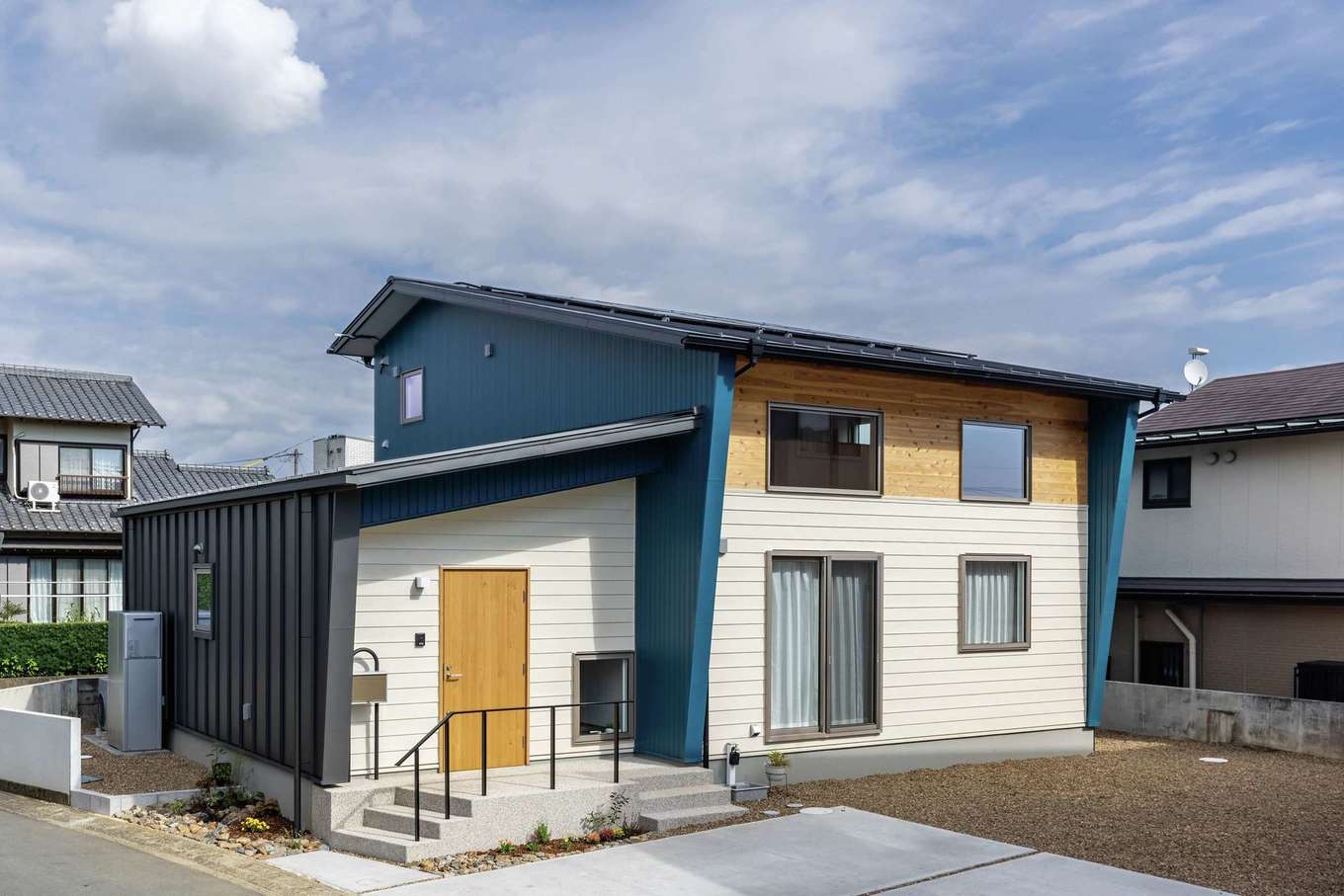 住まいるコーポレーション【自然素材、省エネ、夫婦で暮らす】白・黒・青のガルバリウム鋼板を組み合わせ、杉板がアクセントになった外観デザイン。2階は2つの子ども部屋のみ。片流れの屋根に太陽光発電を搭載している