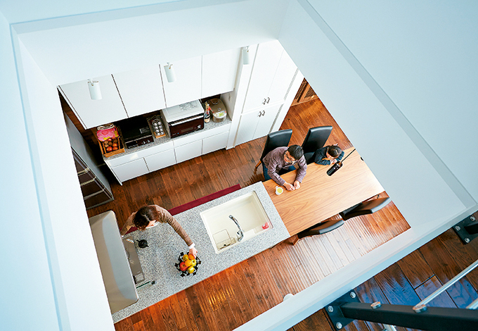 2 階の吹き抜けからキッチンに光が届く。子どもたちがここから手を振る光景もおなじみ