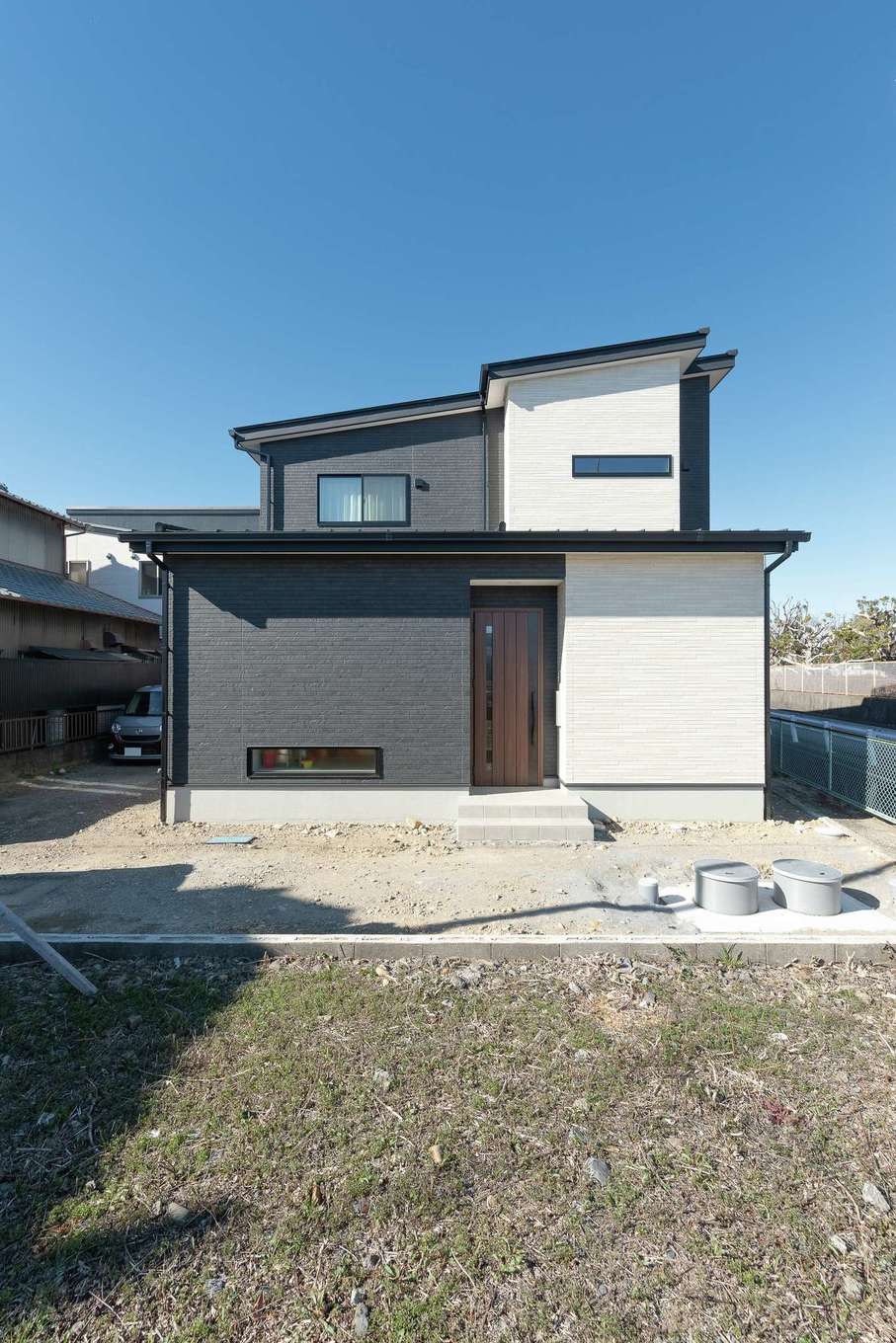 HAPPY HOUSE（山田工務店）【デザイン住宅、子育て、間取り】土地から相談に乗ってもらい、実家との距離や周辺の利便性などの要望とコストとのバランスが取れた敷地が見つかった。外観はブラックとホワイトを張り分け、モダンな印象に。屋根には「コストに余裕があれば」と依頼した太陽光発電（8.6kW）が搭載されている