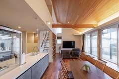 LDKは24畳の広さに、勾配天井が生む開放感と大きな開口がもたらす外部とのつながりを融合。外観からは想像もつかない明るさと大らかさで満たされている。キッチンはただいま動線上にレイアウト。家族の自然な一体感が育まれる