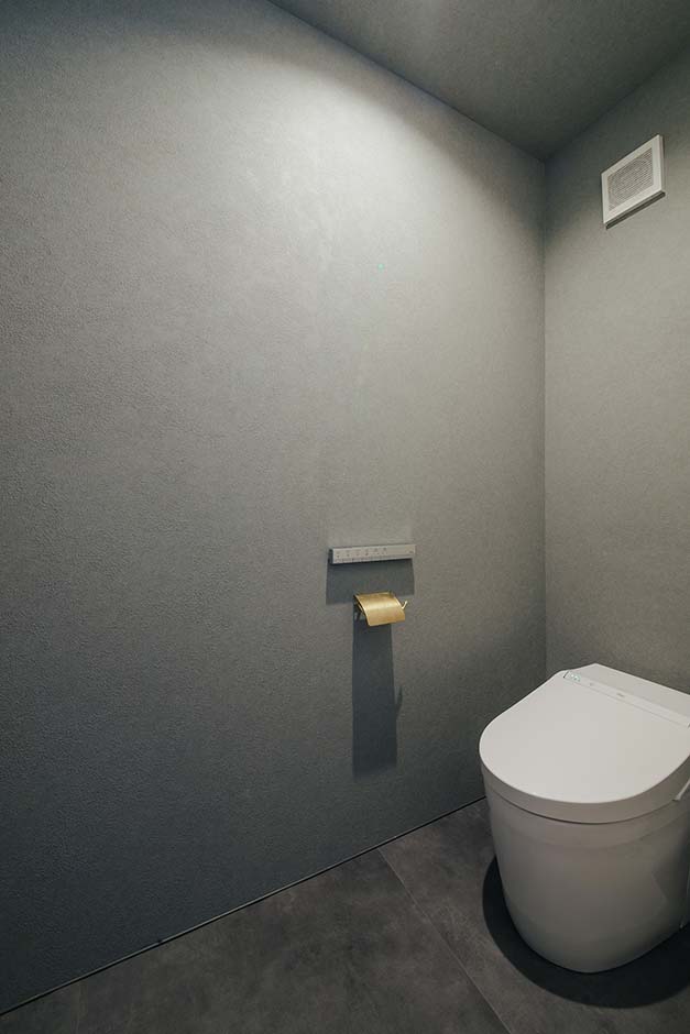 平屋建築ブルーハウス【デザイン住宅、建築家、平屋】洗面脱衣側にあるトイレ。全面グレーのアクセントクロスを採用