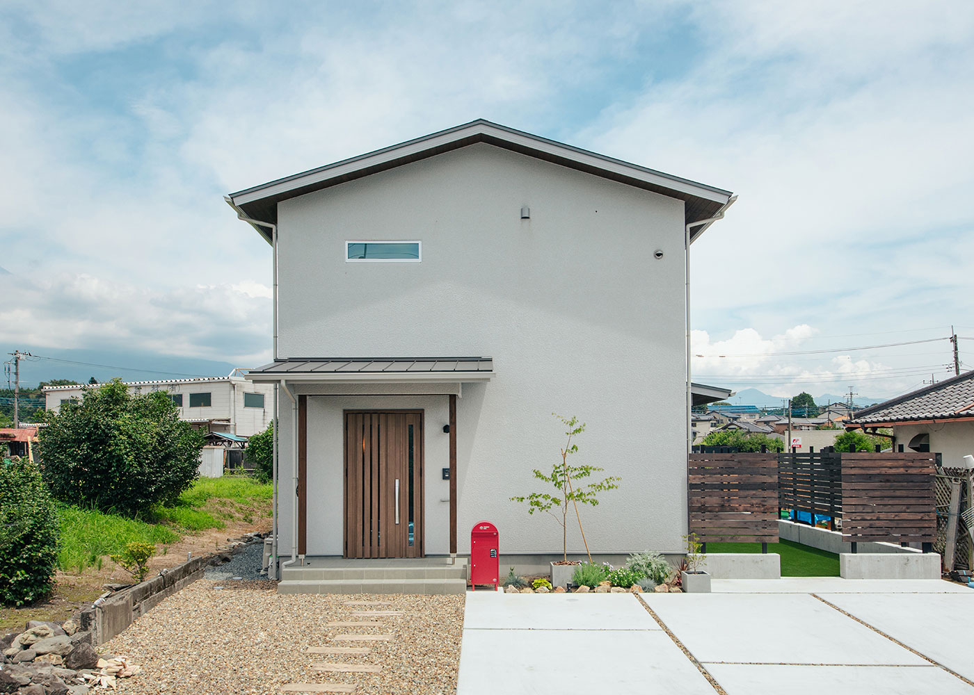 フジモクの家（富士木材）【趣味、自然素材、間取り】切妻屋根＋グレーの塗り壁風の外観は、モダンさ・かわいさ・あたたかさが調和し、周囲の環境にもなじむ。駐車スペースから庭への行き来がスムーズになるよう計画