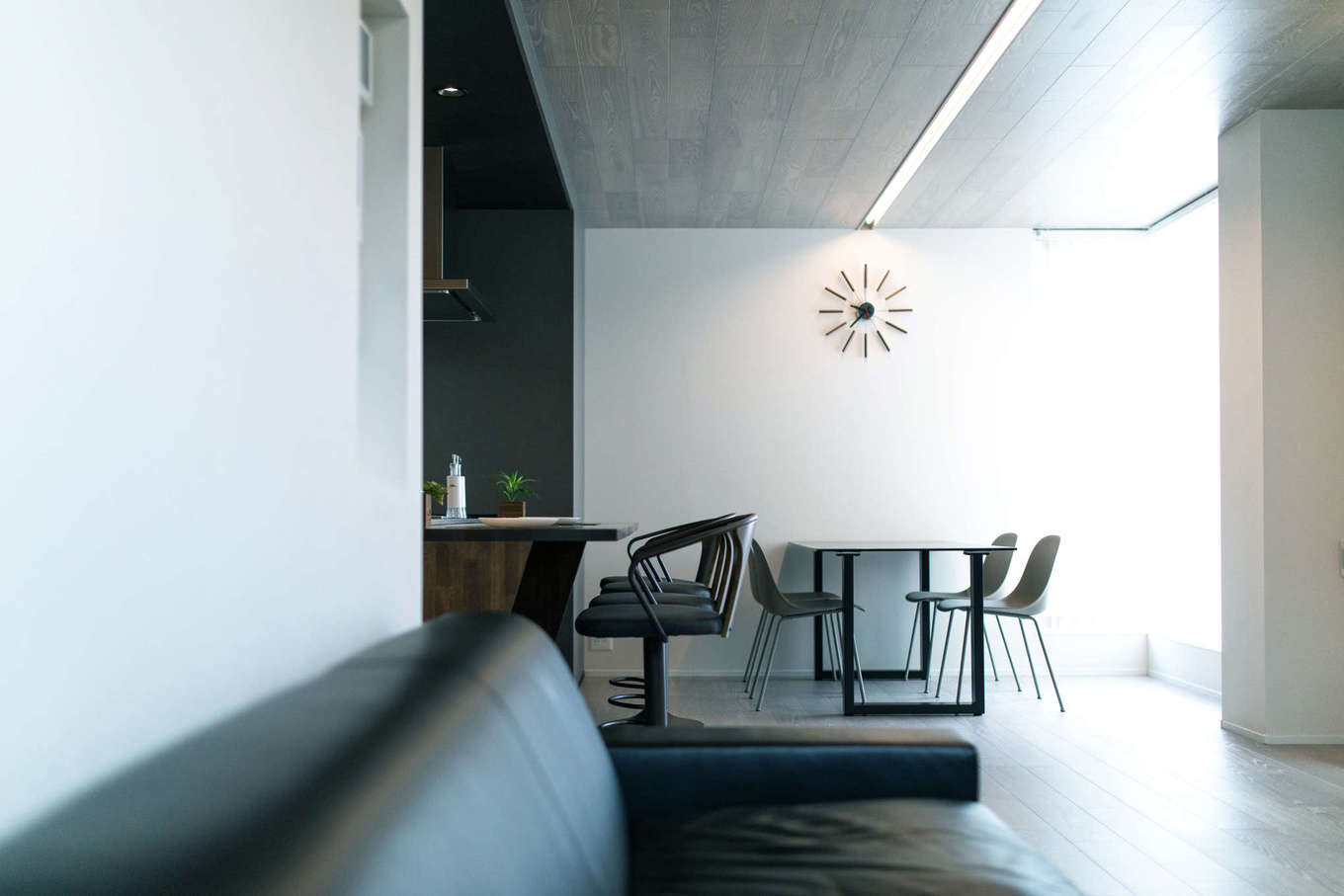 建築システム（狭小住宅専門店）【静岡市駿河区東新田3-2-27・モデルハウス】夫婦ふたりの暮らしをベースにしつつ、時には友人を招いてホームパーティーを開くのにも充分な広さのリビング。天井の中央を貫くスリット上の照明がスタイリッシュ