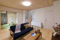 壁面に蓄熱暖房機を設置し、冬もぽかぽかで心地良いリビング。続き間の和室も設けてある