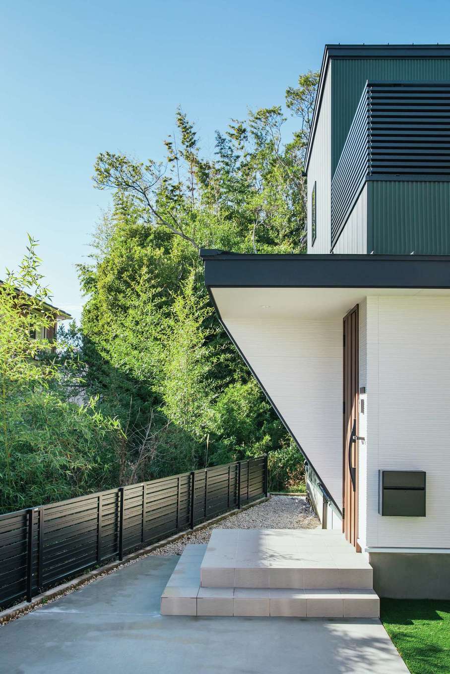 内田建設【デザイン住宅、子育て、間取り】エッジの効いた外観のアプローチ。周囲の竹林の風景とほどよく馴染んでいる。旗竿敷地なので土地価格もリーズナブルで、その分、建物にコストをかけることができた