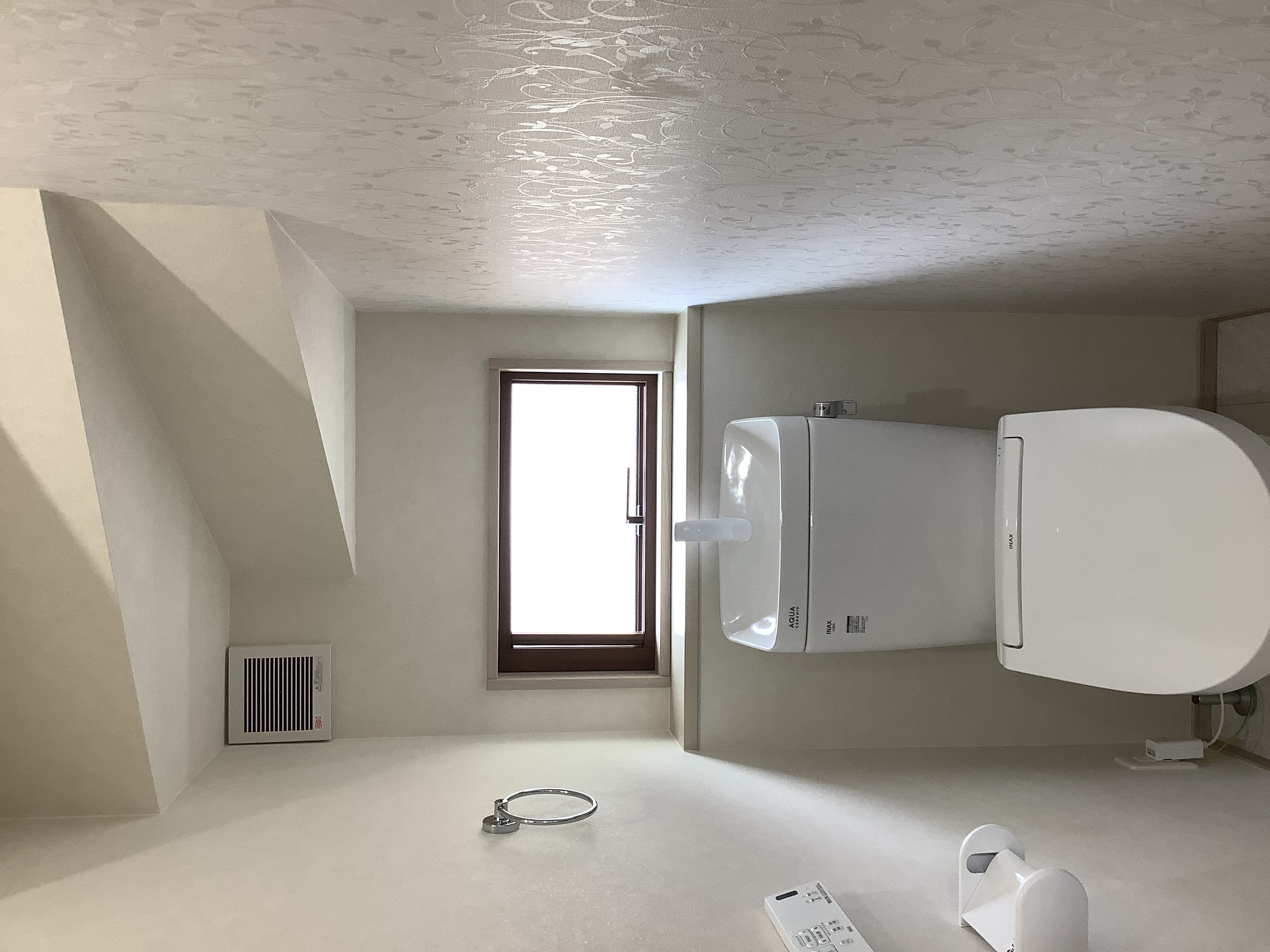 フロート・ハウス｜シンプルで機能的なトイレ空間。窓から自然光が入り、明るく清潔感のあるインテリアが特徴で、快適に使用できるスペース。