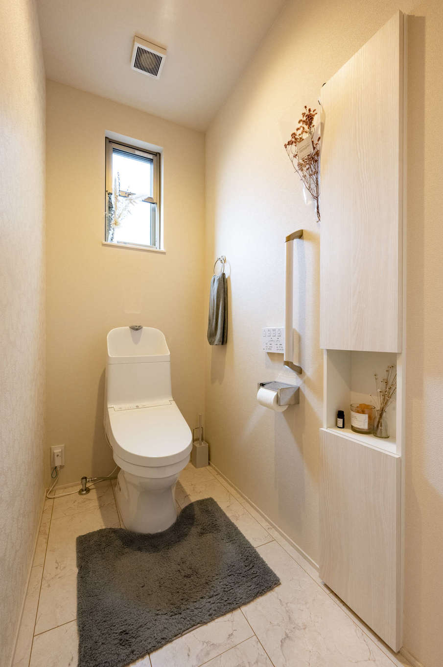 AQURA HOME（アキュラホーム）【デザイン住宅、収納力、間取り】1.25畳のトイレ。収納を壁に埋め込んで空間を広く使えるようにした。花柄のアクセントクロスを採用してやさしい雰囲気を演出