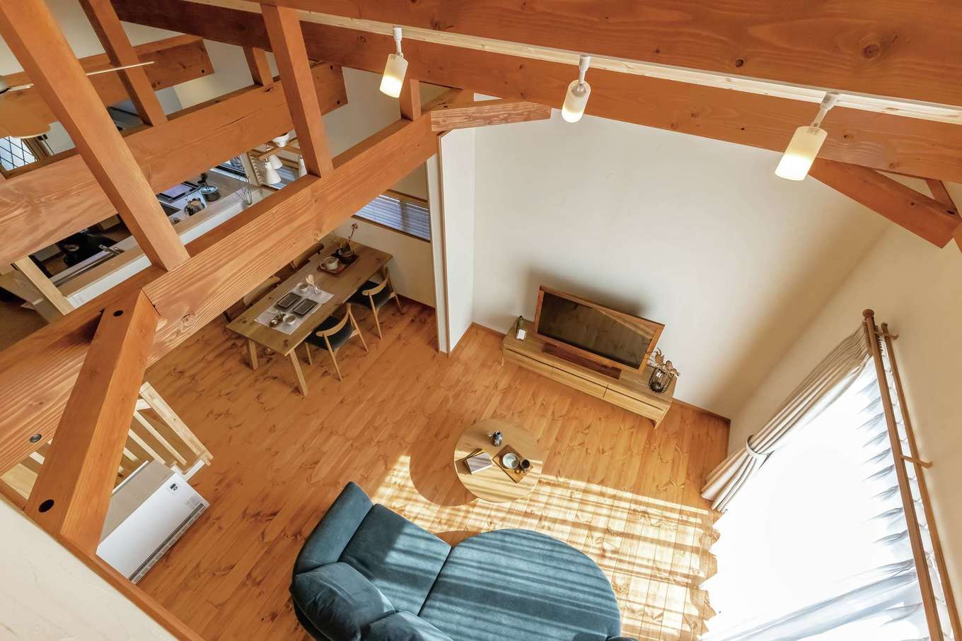 住まいるコーポレーション【デザイン住宅、自然素材、省エネ】2階の寝室から眺めた勾配天井のLDK。梁組みの見事さと天然木の広々空間は、思わず息を飲むほどの存在感