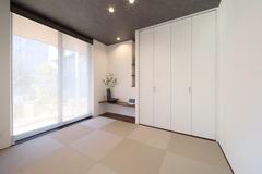 シンプルでモダンな和室。大きな窓から自然光が差し込み、明るく開放的な空間が広がる。白の建具が清潔感を演出する。