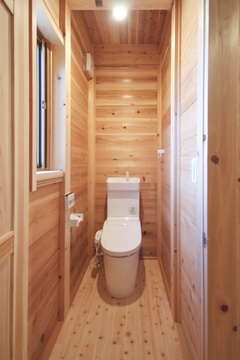 木の温もりに包まれたトイレ空間。明るい木材の内装が、清潔感を引き立てている。コンパクトながら快適な設計で落ち着いたひとときが過ごせる。