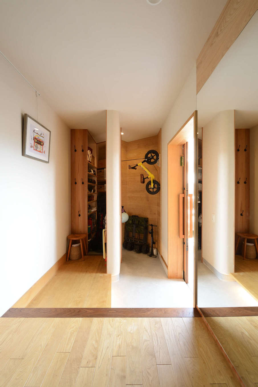 石牧建築【自然素材、狭小住宅、建築家】北面とは思えないほどの明るさと風通しを確保した土間玄関。間仕切り壁の角をRにしてやさしい雰囲気を演出。大きな姿見をビルトインしたことで、空間を広く見せる工夫も