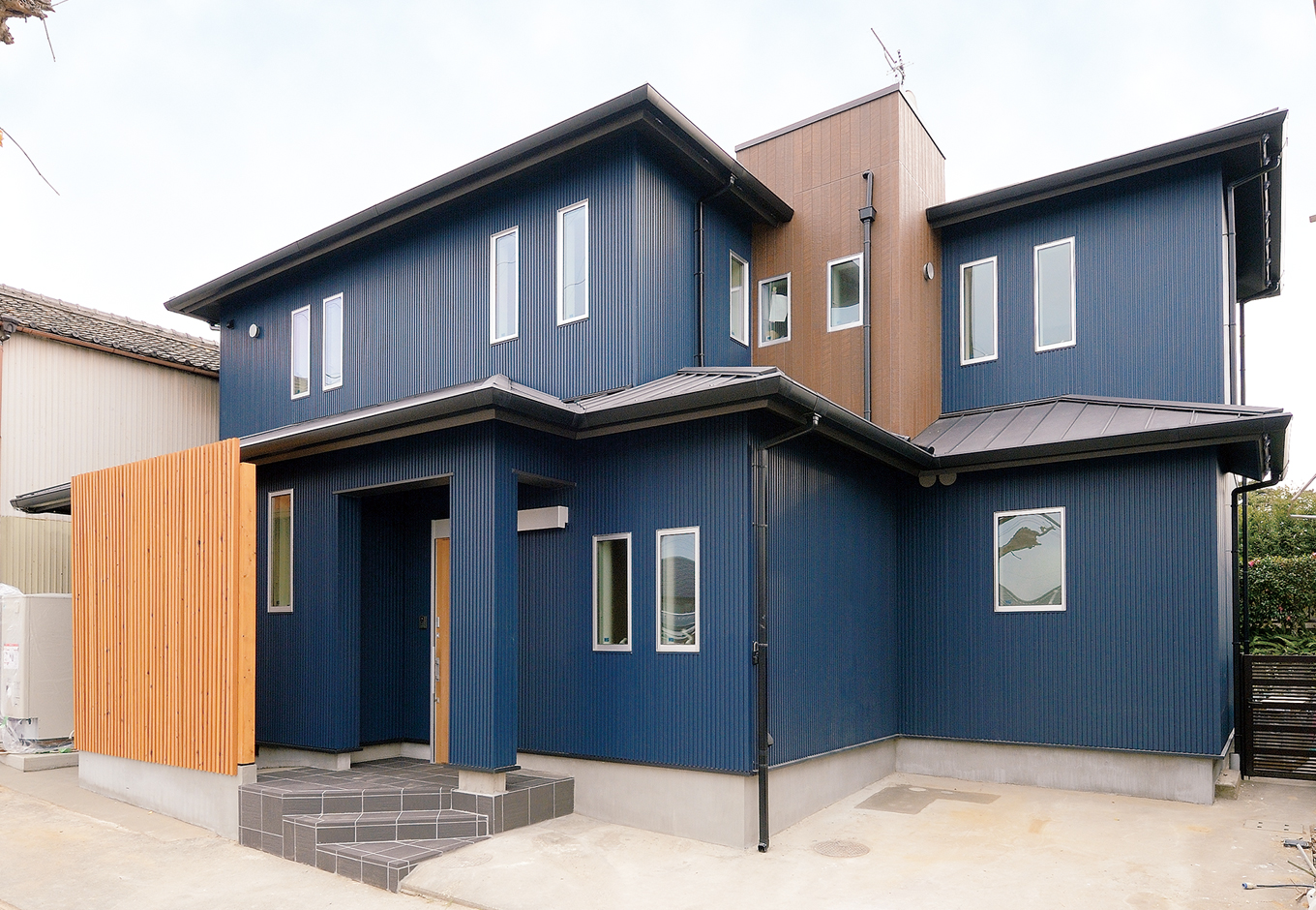 内田建設｜前の家の外壁の上に新しくガルバリウム鋼板を覆うことで、断熱などの居住性が改善。さらに廃材も減りコスト削減にも。玄関横には収納スペースを増築