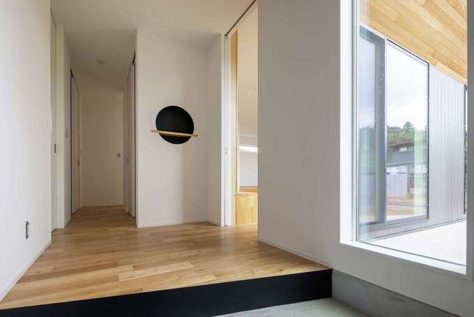 FIXの大きな窓に視線が抜けていく開放的な玄関ホール。丸型のニッチは