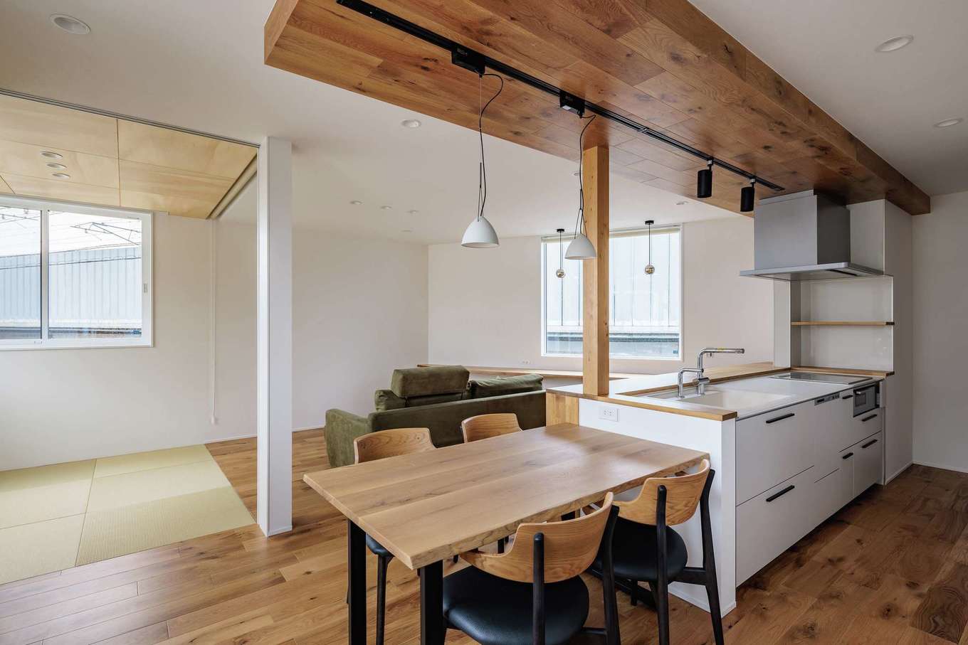 tact design firm【デザイン住宅、狭小住宅、間取り】キッチンとダイニングテーブルを横一直線につなげたストレートダイニングで家事効率をUP。下がり天井はフローリングと同じ無垢オーク材を使用し、和モダンな雰囲気に