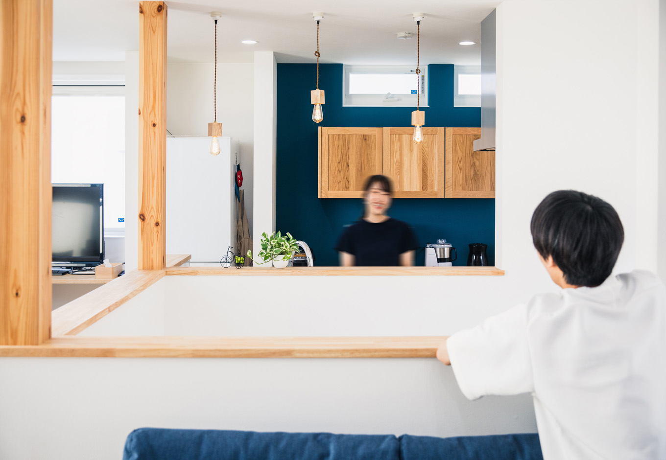SEIEN ARCHITECT【趣味、建築家、1000万円台】吹抜けの階段ごしに、アイランドキッチンとリビングを向かい合わせに配置した間取りは、他の家にはなかなかないユニークなシチュエーション。程よい距離がそれぞれの空間に落ち着きをもたらしている。調理をしながら会話も楽しめる