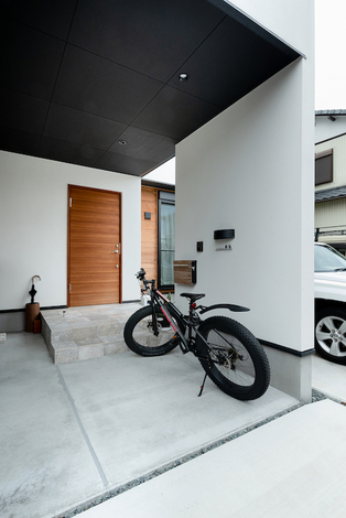 木目調の玄関ドアが真っ白な外観のアクセントに。駐輪スペースも広々確保