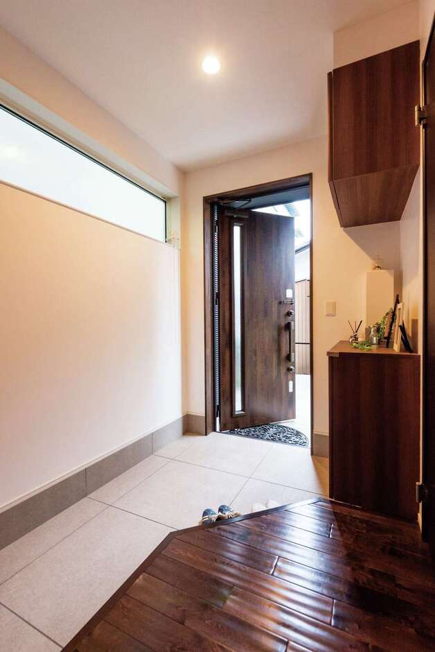 子世帯の玄関。框を斜めに切り、ハイサイドライトを採用したことで目線が抜け、圧迫感がない